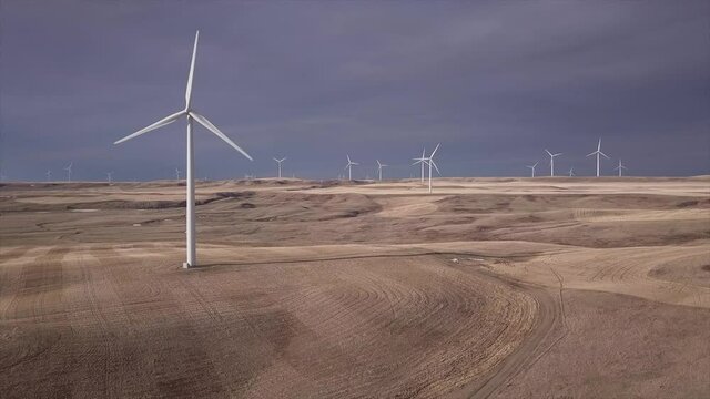 Creative cinemagraph of windfarm with only one windmill spinning