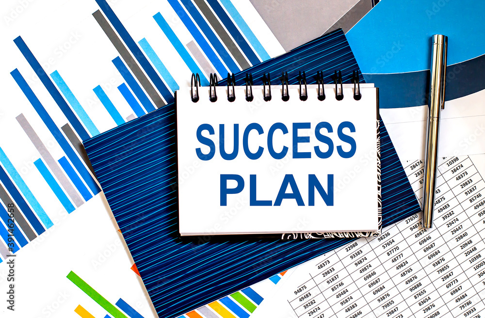 Poster notebook with text success plan on office table with office supplies on chart background