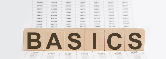wooden cubes with letters BASICS on chart background