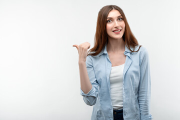 Beautiful girl pointing and showing with thumb to the side with happy face, smiling. Presenting your product