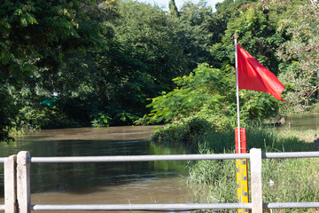red flag and yellow water level indicator in river