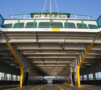 Car ferry on the water, car deck and upper deck, two cars and spaces