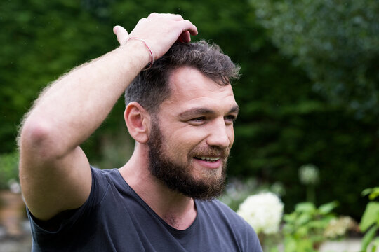 Man sitting in garden tapping his head,  EFT therapy.