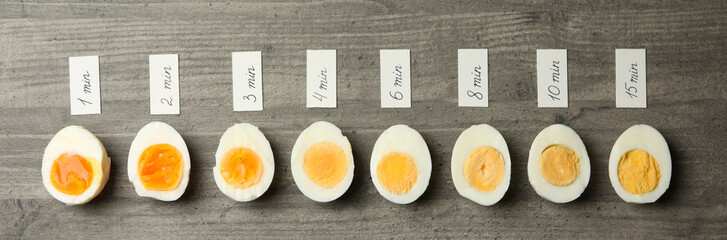Boiled eggs and labels with cooking time on gray background