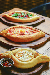 Khachapuri with brie cheese served on a wooden board. Traditional meal, Georgian cuisine concept