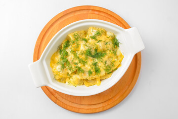 Ravioli dumpling with fresh greenery served in a white pot over white background. Isolated on white.
