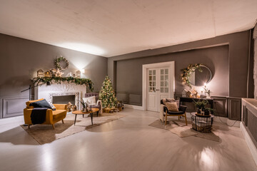 Classic apartments with decorated christmas tree and presents. Christmas evening in the light of candles and garlands. Living with fireplace and stucco.