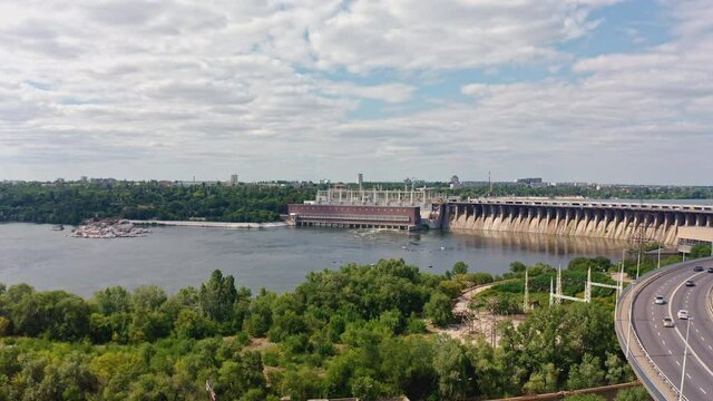 The beautiful river is surrounded by green and fresh vegetation in the city. Dnieper hydroelectric power station in Zaporozhye