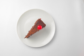 Chocolate cake on the white plate. One piece of soft cream chocolate cake served on a plate over white background.