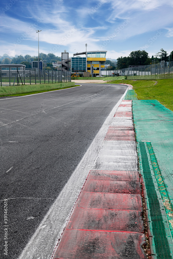 Wall mural Motor sport circuit asphalt track background curb close up on straight and green field