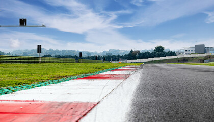 Motor sport circuit asphalt track background kerbs close up on straight and green field