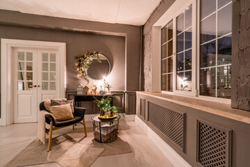 Classic apartments with decorated christmas tree and presents. Christmas evening in the light of candles and garlands. Living with fireplace and stucco.