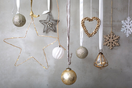 Christmas decorations, close up of silver, white and golden Christmas baubles on ribbons