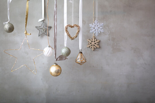 Christmas decorations, close up of silver, white and golden Christmas baubles on ribbons