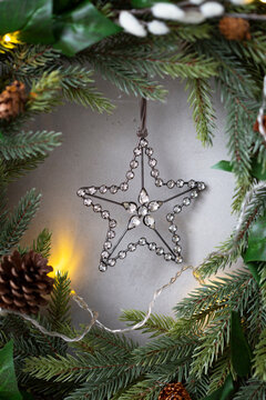 Christmas decorations, close up of silver star on Christmas wreath.