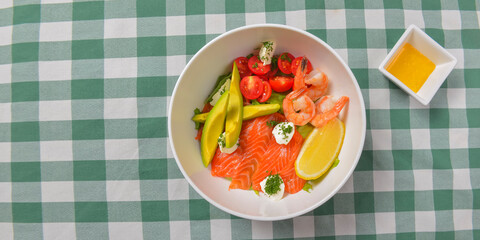 Fresh salad with seafoods, tomato and herbs. Red salmon, small shrimps, avocado, cherry tomatoes.