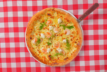 Supreme Pizza top view, flat lay, over red plaid table cloth. Italian cuisine concept, delicious cheese pizza on table.