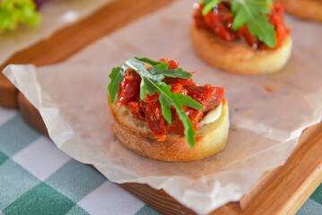 Juicy fresh Italian bruschetta over green plaid table cloth. Traditional Italian cuisine concept.