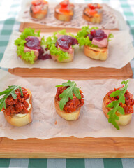 Juicy fresh Italian bruschetta over green plaid table cloth. Traditional Italian cuisine concept.