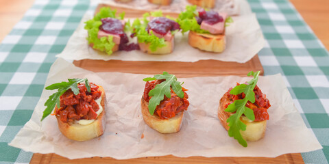 Juicy fresh Italian bruschetta over green plaid table cloth. Traditional Italian cuisine concept.