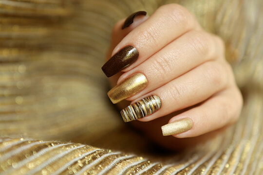 Fashionable Manicure With A Matte Golden Color Of Nail Polish And Brown On A Long Nail Shape.