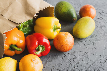 Fruits and vegetables in brown paper bag. Grocery delivery. Plant based diet. Local fruits and veggies
