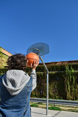 Man throwing a ball into the basketball net.