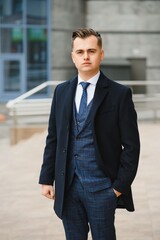 High fashion look.Young stylish confident handsome businessman model in suit clothes walking in the street.
