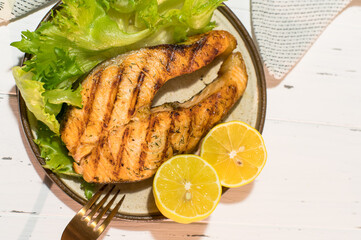 Homemade organic salmon steak with lettuce leaves