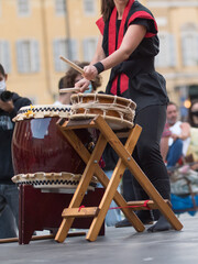 Obraz na płótnie Canvas Girl Playing Drums of Japanese Musical Tradition during a Public Outdoor Event