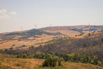 Typical Apulian landscape of southern Italy with hills, plains, fields and wind turbines in the...