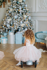 Girl playing near the Christmas tree. Beautiful Christmas decor