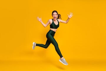 Profile photo of sportive lady jump high training marathon race competitive wear sports suit shoes isolated yellow color background