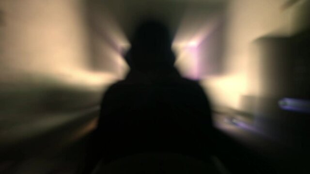 Motionblur effect on a man wearing some dark clothes and working on pc.
