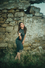 girl with a beautiful figure on the background of an old stone wall
