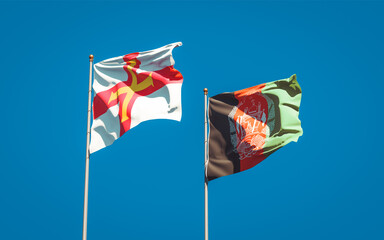 Beautiful national state flags of Guernsey and Afghanistan together at the sky background. 3D artwork concept.