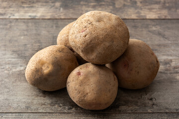 Fototapeta premium Raw potatoes on wooden table