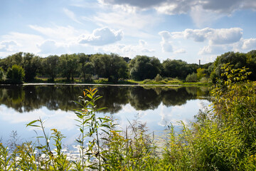 Tver; Tver region. Landscape Park on the river Tmaka. Reflection of trees in the river.