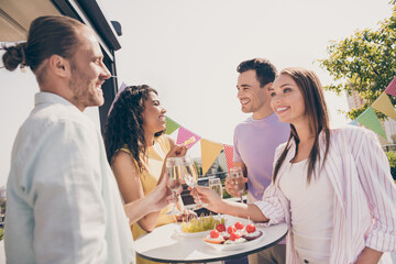 Portrait of company of four funny fellows arms hold champagne clink positive vibes meeting outdoors