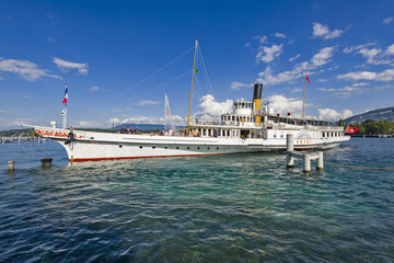 vintage steamboat arriving at a pier on Lake Geneva in Geneva Switzerland.