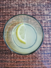 Slice of lemon in glass on the table top view