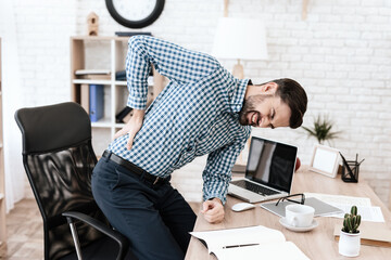 Man holding on to side while standing in an office