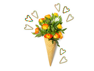Fresh yellow-orange spray roses in a waffle cone on a white isolated background. Hearts are made from candy canes. Postcard for February 14.