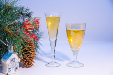 Glasses with a drink, a Christmas tree branch, toys. New Year's template.