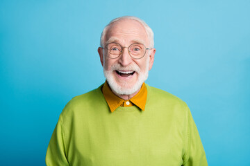 Photo of retired old man open mouth shiny smile excited wear glasses green pullover isolated blue...