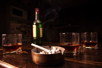 cigarette smoking and drinking alcohol. Glass of whiskey, cigarettes and ashtray