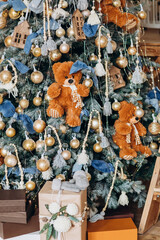 Beautiful Christmas tree with gifts for children, decorated with toys, bears, bows  - 391491665