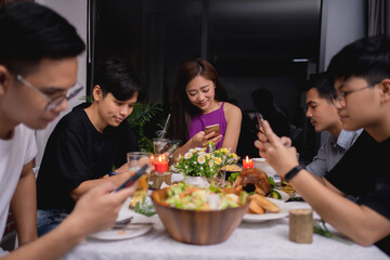 Group of friends was playing on the phone at a party and drinking beer in the house.