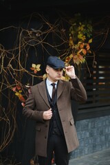 A man posing in the image of an English retro gangster of the 1920s dressed in Peaky blinders style...