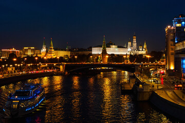 Fototapeta na wymiar View of the Kremlin and the Moskva River from the Patriarchal Bridge at night, river tram illuminated by lights
